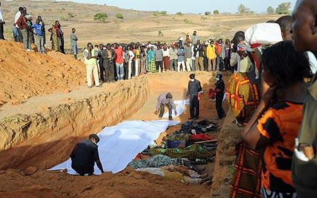 Photo by : AFP/GETTY - local mourners gather during a mass burial of the victims in the 7 January attacks 