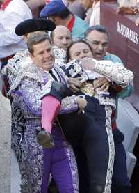 goring bull fighter matador being carried after horrific injury