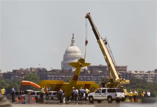 The bi-plane which flipped over was lifted using a crane - Photo by : AP /Kevin Wolf