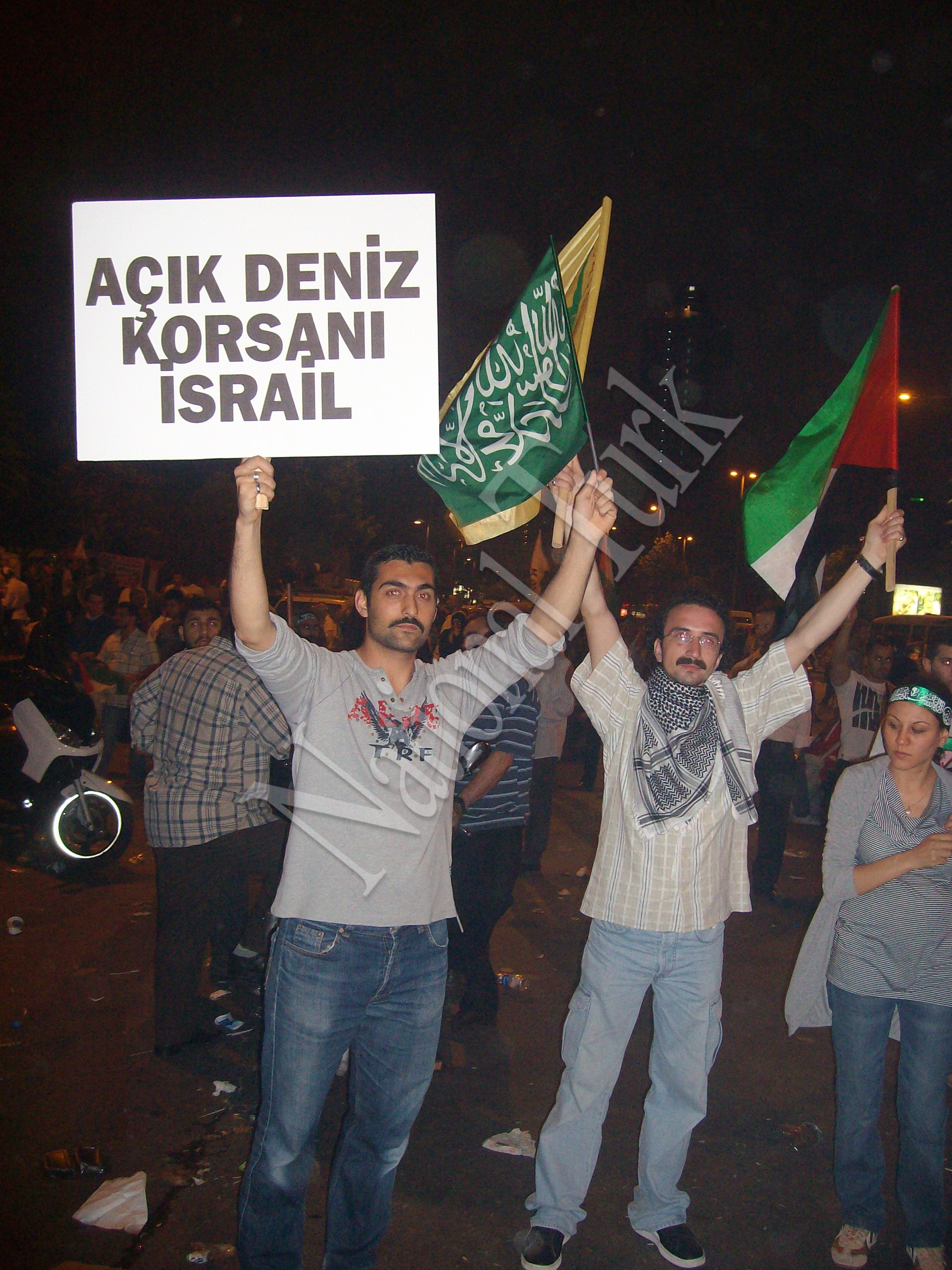 Protestor in front of the Israeli Embassy in Istanbul holding a placard writing Open Water Pirates Israel