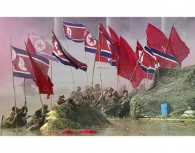 South Korean Army soldiers, acting as North Korean soldiers, hold North Korea's flags as they take part in a re-enactment of the Nakdonggang Battle in Chilgok