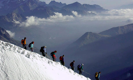 Climbers, rope-tied to eachother walk down the Aiguille du Midi, below Mont Blanc, in the French Alps