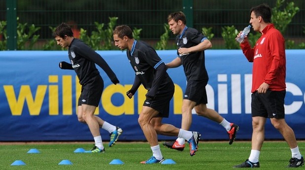 England coach Gary Neville (right) oversees Leyton Baines (left), Phil Jagielka (second left) and James Milner during a training session at London Colney, 