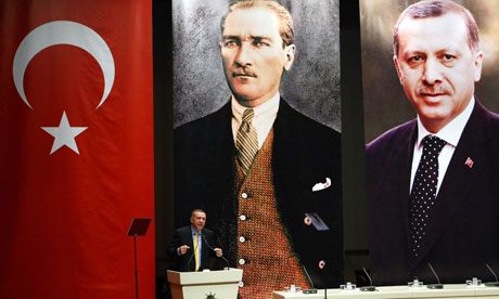 AKP head Tayyip addresses in front of portraits of himself and Mustafa Kemal Ataturk, the founder of modern Turkey. Critics state Erdogan creates a cult of personality !