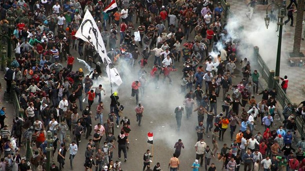 Protesters demonstrating against Egypt's Islamist President Mohamed Morsi run from tear gas fired by Egyptian riot police during clashes in Cairo's landmark Tahrir square on November 23, 2012. Morsi has assumed temporary sweeping powers that supporters say will cut back a turbulent and seemingly endless transition to democracy, but outraged critics say he has now become a dictator. Protesters demonstrating against Egypt's Islamist President Mohamed Morsi run from tear gas fired by Egyptian riot police during clashes in Cairo's landmark Tahrir square on November 23, 2012. Morsi has assumed temporary sweeping powers that supporters say will cut back a turbulent and seemingly endless transition to democracy, but outraged critics say he has now become a dictator.