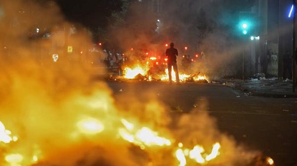 A man stands between bonfires lit by demonstrators in Rio de Janeiro A man stands between bonfires lit by demonstrators in Rio de Janeiro