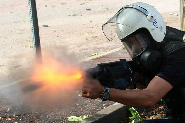Turkish riot police officer fires tear gas during clashes with protestors between Taksim and Besiktas in Istanbul on June 3, 2013 during a demonstration against the demolition of the park. Turkish riot police officer fires tear gas during clashes with protestors between Taksim and Besiktas in Istanbul on June 3, 2013 during a demonstration against the demolition of the park.