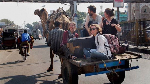 Foreign tourists enjoying camel-cart ride in India. File Pic