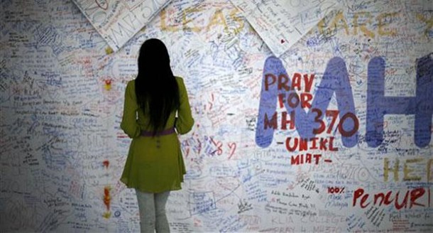 A woman reads messages and extends well wishes to passengers onboard Malaysia Airlines MH370 missing. File pic