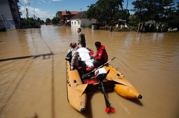 Serbian army soldiers evacuate people on a boat in the flooded town of Obrenovac Serbian army soldiers evacuate people on a boat in the flooded town of Obrenovac