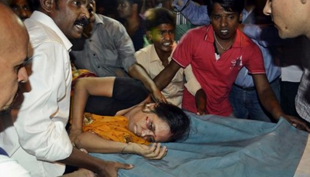 A woman injured in stampede in India being shifted to hospital.