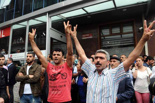 Kırmızı tişörtlü şahıs HDP'lilerle birlikte zafer işareti yapıyor