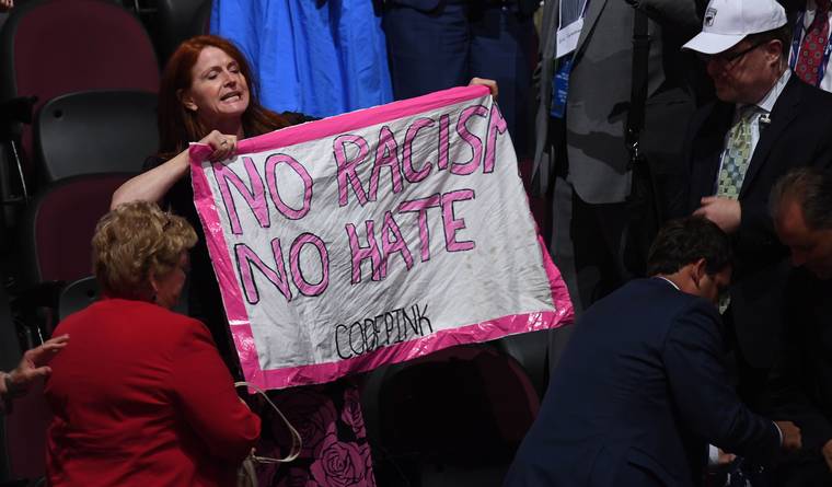 Trump'ı protesto eden kadını bayrakla gizlemeye çalıştılar (Video) 1 trump protesto
