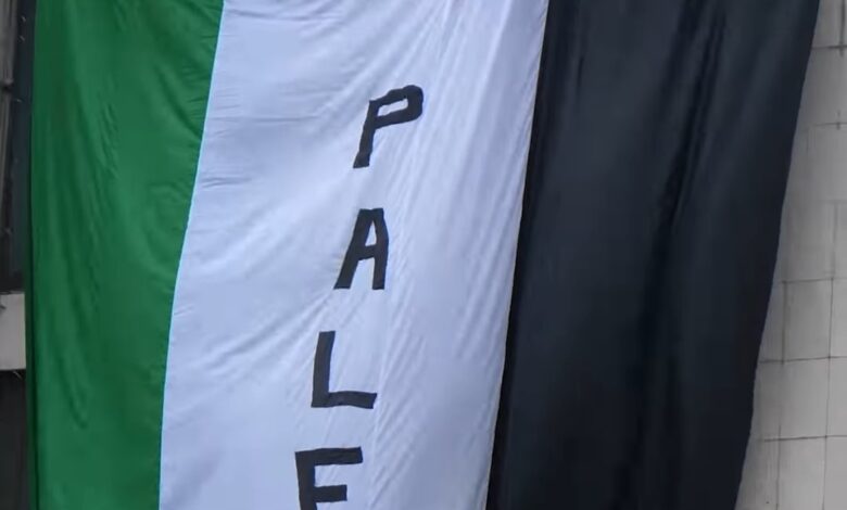 Priştine’de oynanan Kosova-İsrail maçı öncesi, Kosovalı gençler, tarihi Grand Oteli’ne üzerine “Filistin’e özgürlük” yazılan Filistin bayrağı astı.