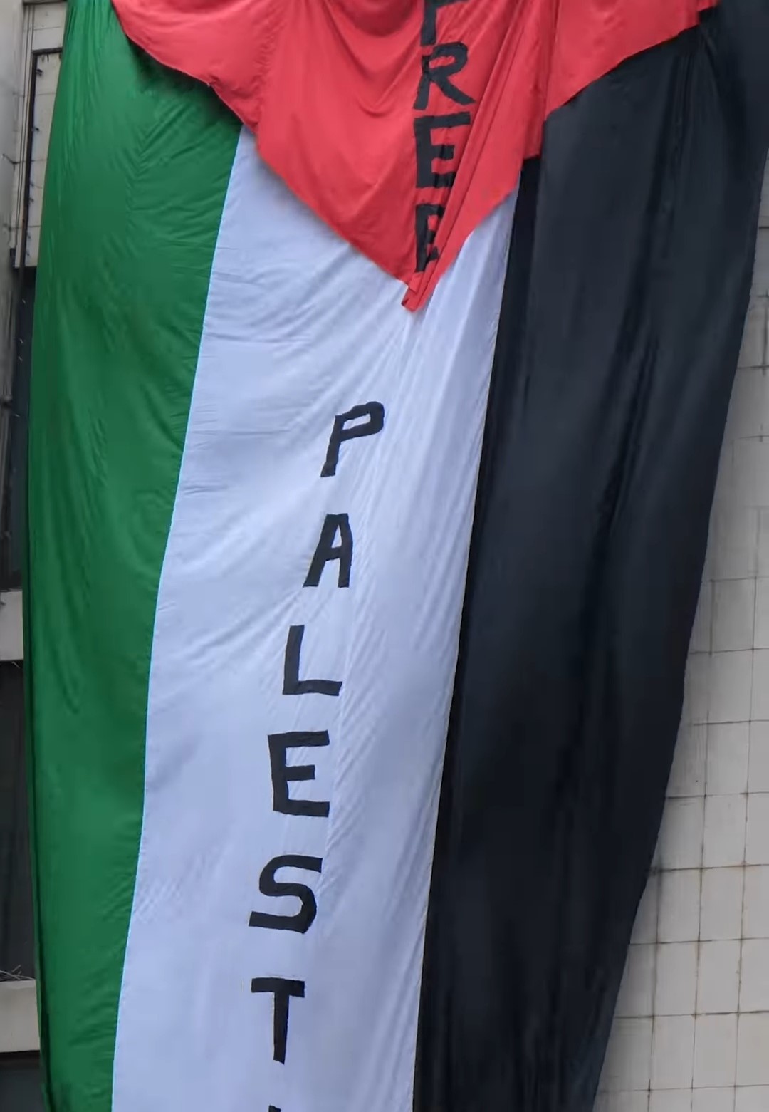 Priştine’de oynanan Kosova-İsrail maçı öncesi, Kosovalı gençler, tarihi Grand Oteli’ne üzerine “Filistin’e özgürlük” yazılan Filistin bayrağı astı.